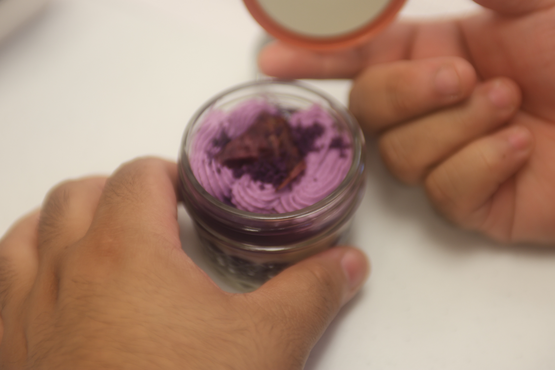 Close-up of swirled ube cream piped into a small glass jar.