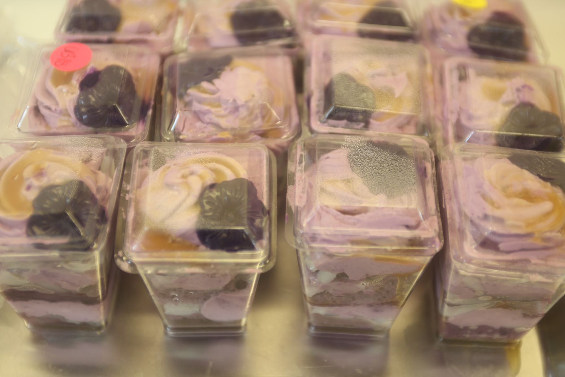 Purple ube dessert cups arranged in clear containers.